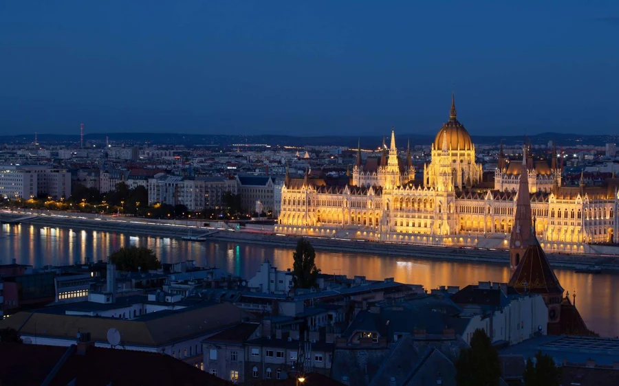 The Hungarian Parliament lit up across the Danube at dusk