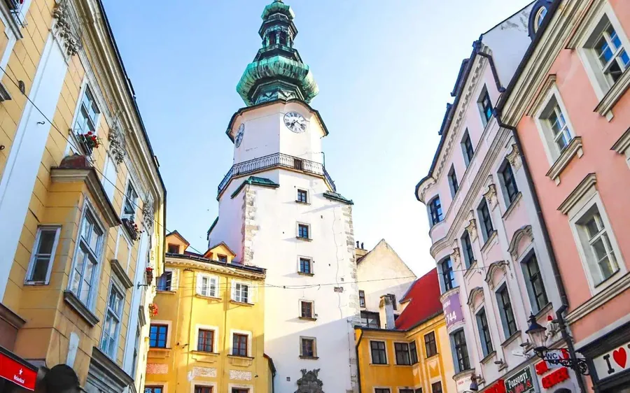 Michael’s Gate tower between pastel houses in Bratislava