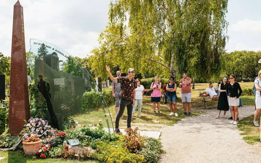 A guide talking to a group on a garden path at the Central Cemetery