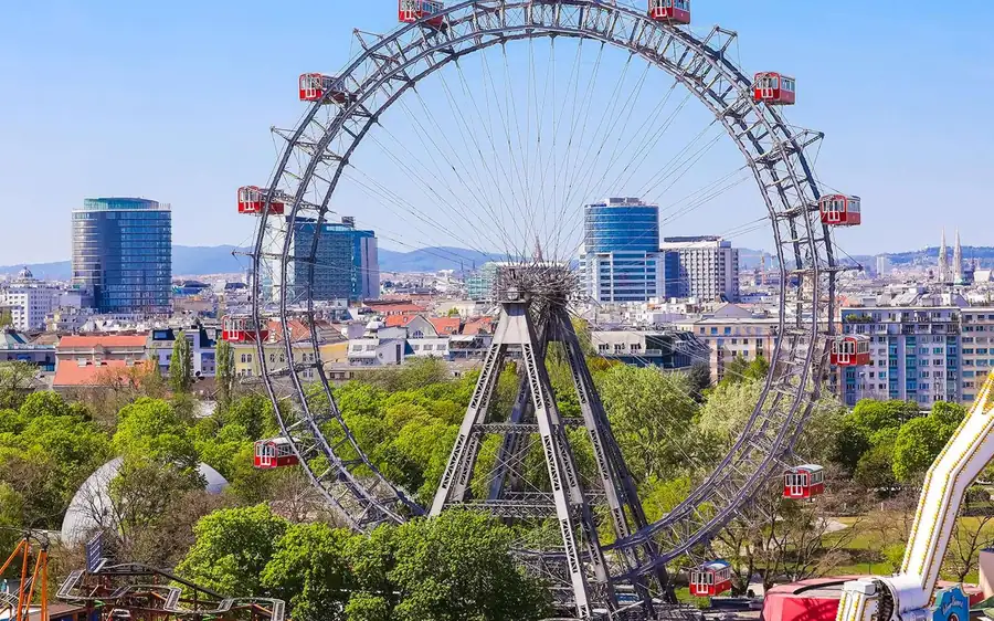 The Giant Ferris Wheel with its red cabins above the trees of the Prater