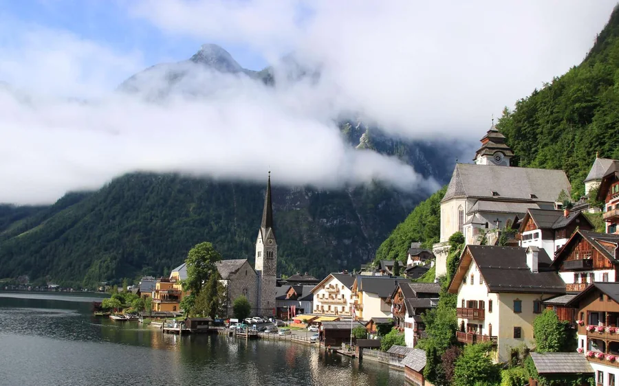 The church spire and houses of Hallstatt below misty mountains