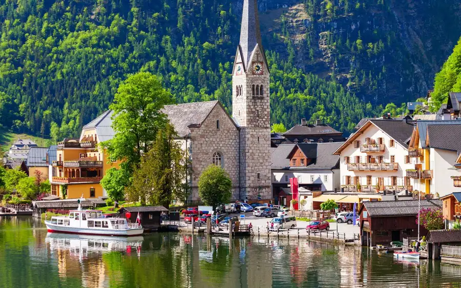 The church tower and lakeside houses of Hallstatt with moored boats