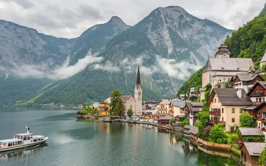 Hallstatt and a passenger boat on the lake below high peaks