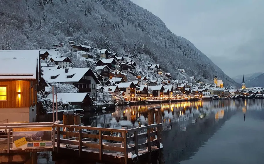 Snow-covered Hallstatt and its lights reflected in the lake