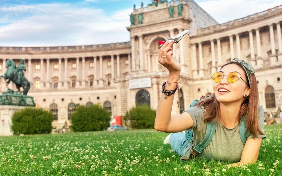 A visitor lying on the lawn in front of the Hofburg and an equestrian statue