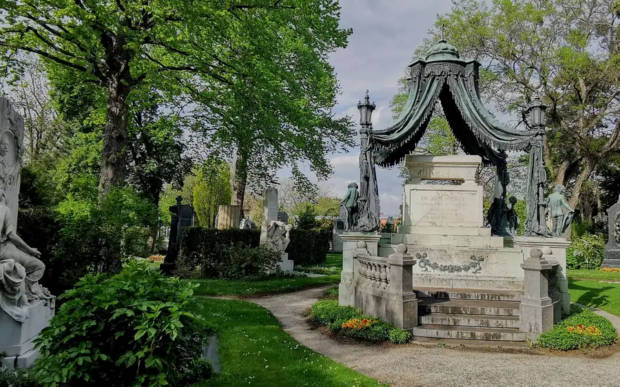 An ornate canopied monument among trees at the Central Cemetery
