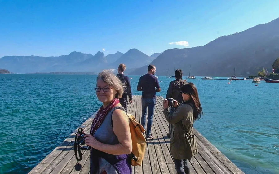 Visitors with cameras on a wooden jetty over a blue alpine lake