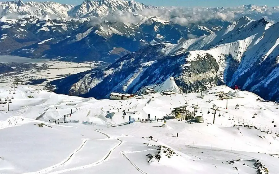 Snowy mountain slopes and ski lifts high above a valley